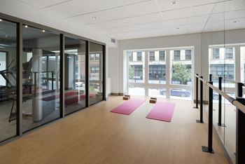 A yoga studio with pink mats and glass walls.